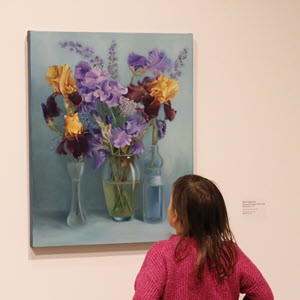 Girl looking up at a flower painting
