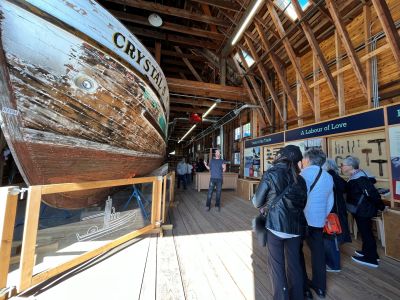 Individuals participating in a boatbuilding tour